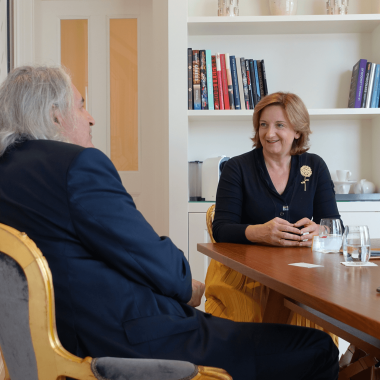 Andrea Fuchs und Thomas Rihl im Gespräch an einem Tisch in einem der schönsten Zimmer im Hotel Sans Souci Wien.