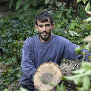 Adullah Al Jabr posiert neben einem gefällten Baum.