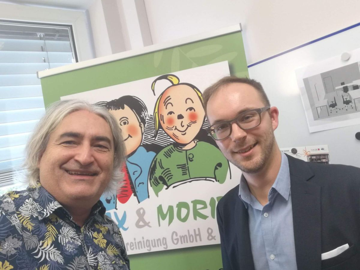 Selfie: Rene Holubar und Thomas Rihl vor dem Logo von Max und Moritz im Büro von Rene Holubar.