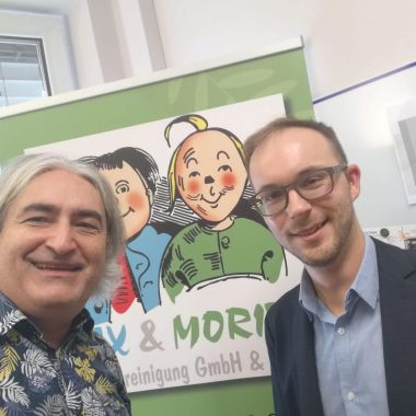 Selfie: Rene Holubar und Thomas Rihl vor dem Logo von Max und Moritz im Büro von Rene Holubar.